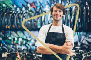 Bike shop owner stands proudly in front of new stock.